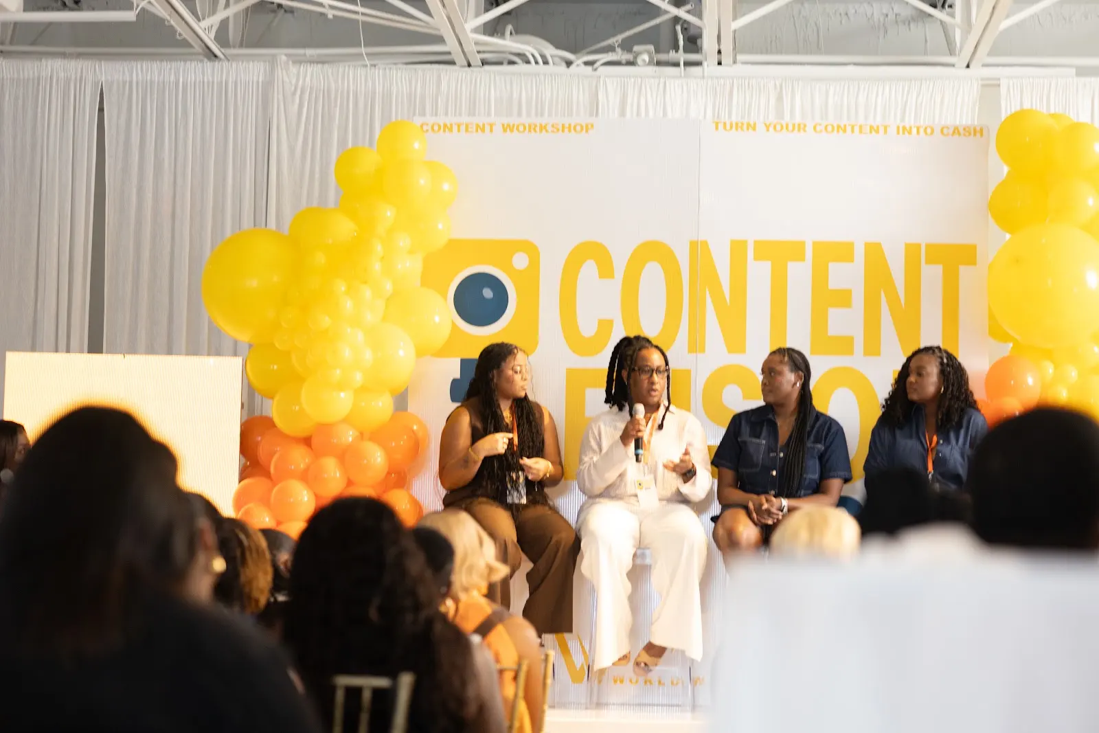 Panelists speaking to a full workshop audience inside the venue