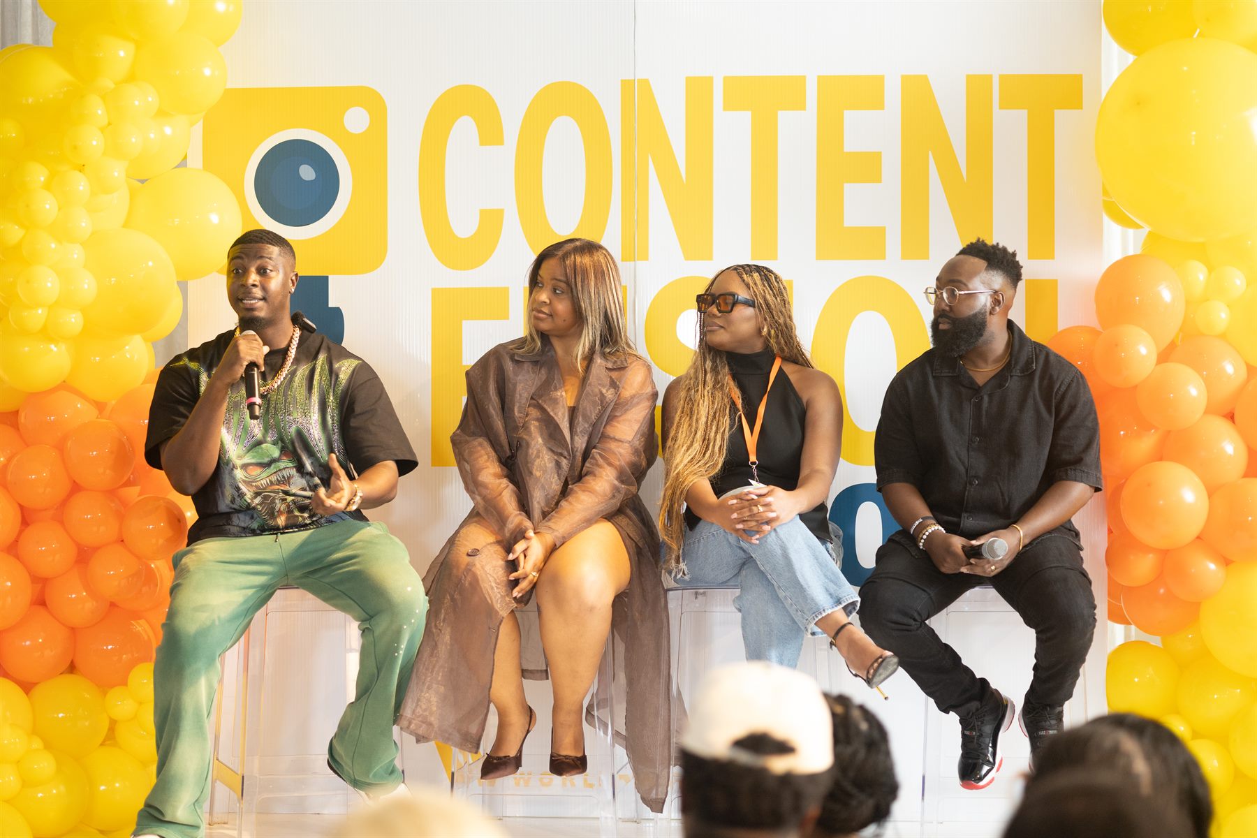 Content Reign panel with four guests against a yellow and orange balloon backdrop