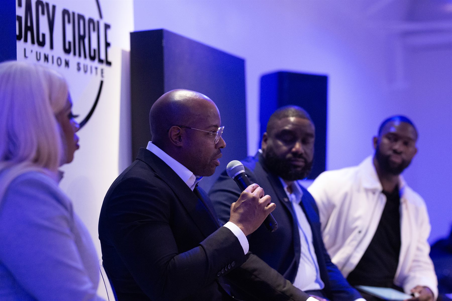 Legacy Circle panel discussion lit in cool blue